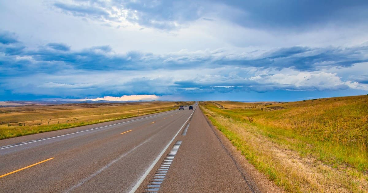 Scenic highway in Montana with dramatic clouds and vast landscapes. Perfect for travel and adventure themes.
